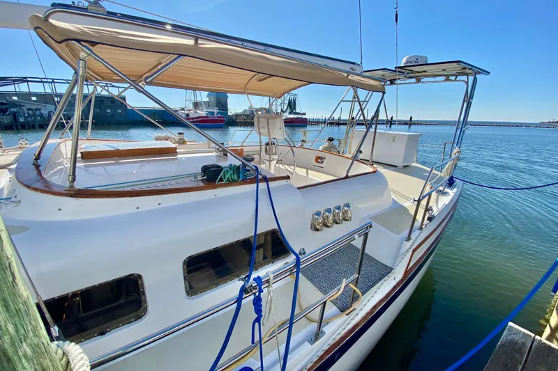Slide: The Image of 1980 Wellington 44 yacht docked at marina under clear blue sky. - 7