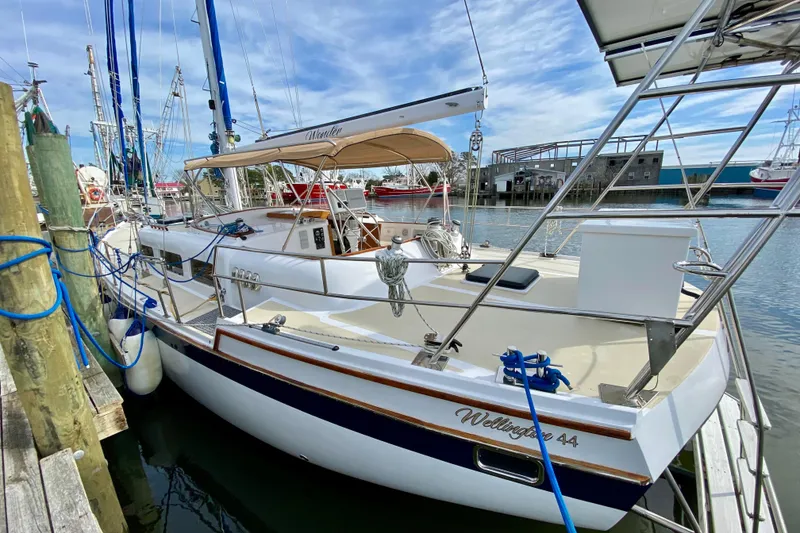 Slide: The Image of 1980 Wellington 44 sailboat docked at marina, featuring sleek design and spacious deck. - 8