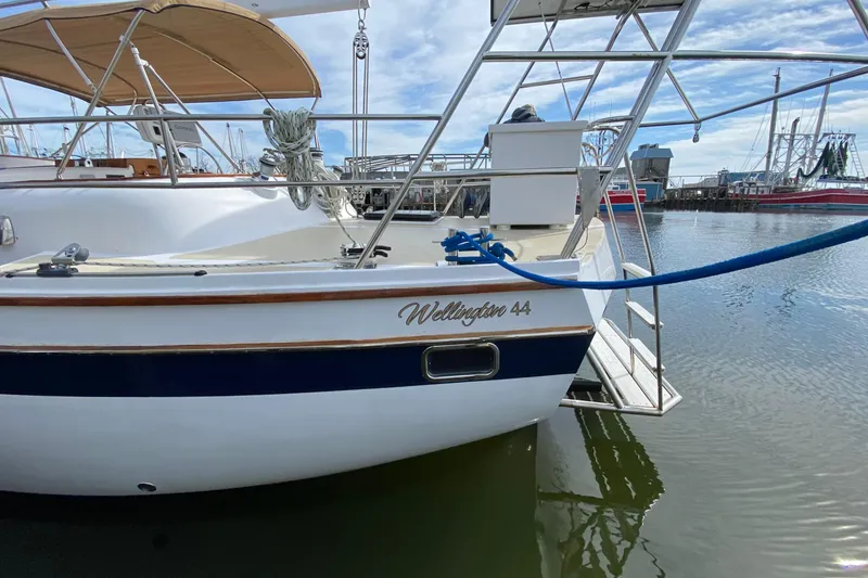 Slide: The Image of 1980 Wellington 44 sailboat docked in marina, featuring elegant design and blue accents. - 9