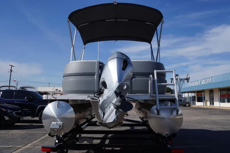 Slide: The Image of 2026 Avalon GS Quad Lounge 18' pontoon boat with canopy and motor, parked outdoors. - 1