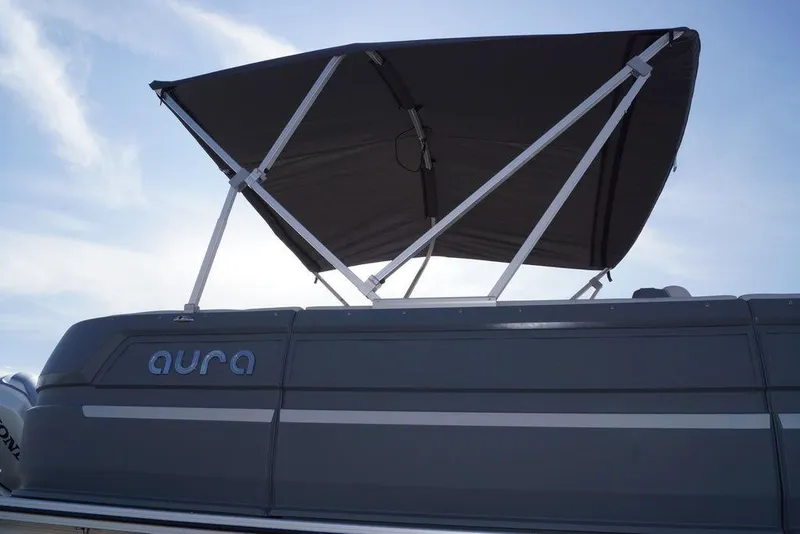 Slide: The Image of 2026 Avalon GS Quad Lounge boat with canopy, side view under clear sky. - 2