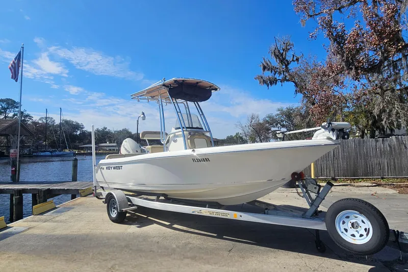 Slide: The Image of 2017 Key West 189 FS boat on trailer by a dock under a clear blue sky. - 10