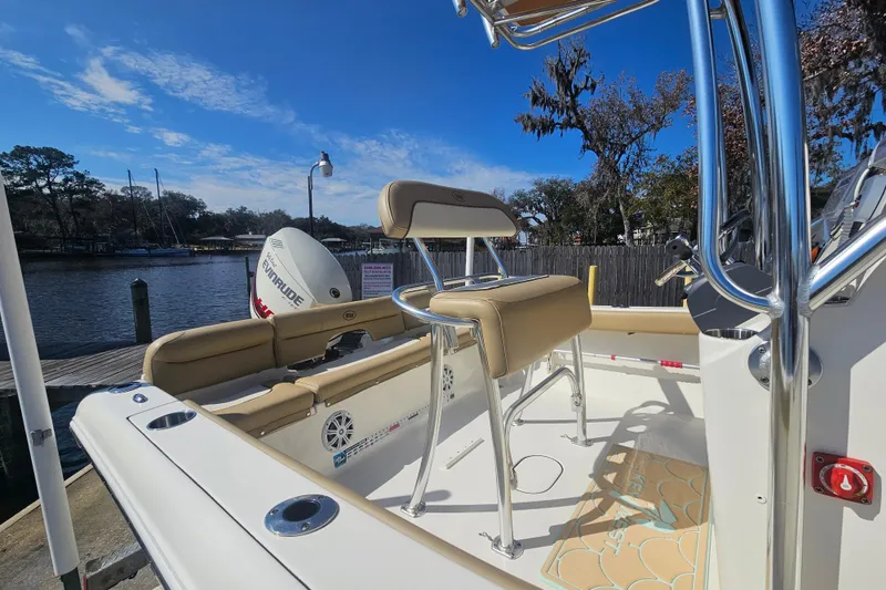 Slide: The Image of 2017 Key West 189 FS boat with seating and Evinrude engine by a dock. - 12