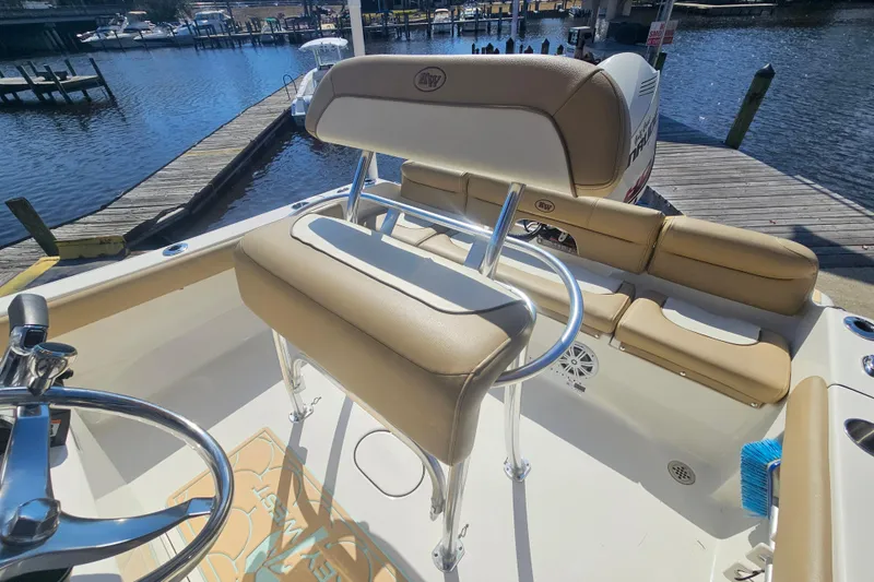 Slide: The Image of 2017 Key West 189 FS boat interior with tan seating, docked by the water. - 15