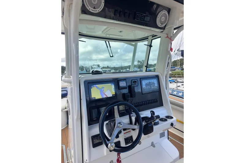 Slide: The Image of 2020 World Cat 320 CC boat dashboard with navigation screens and steering wheel. - 8