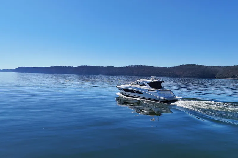 Slide: The Image of 2016 Sea Ray Sundancer 510 cruising on a serene lake under a clear blue sky. - 10