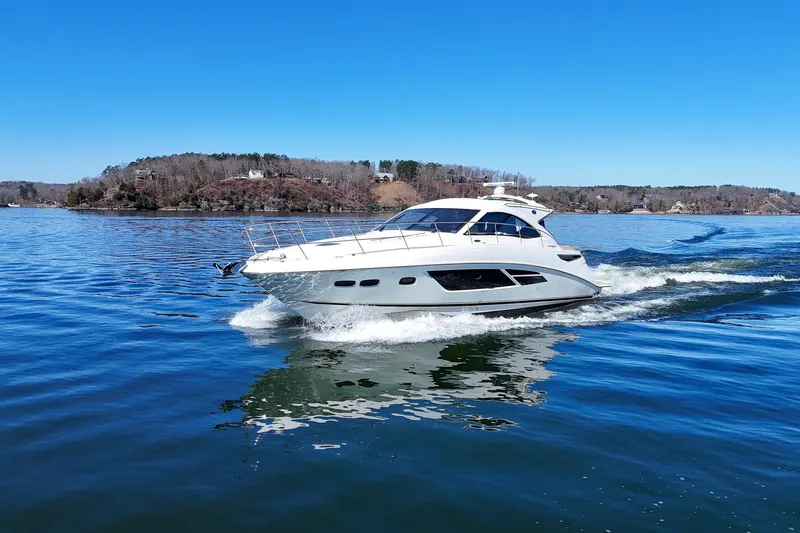 Slide: The Image of 2016 Sea Ray Sundancer 510 cruising on a serene lake under a clear blue sky. - 6