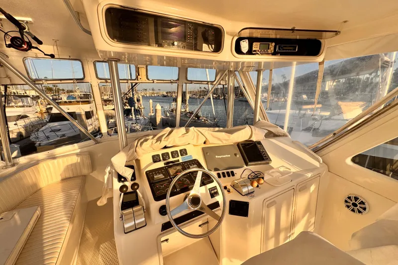 Slide: The Image of 1999 Ocean Yachts 48 Super Sport helm with marina view at sunset. - 12