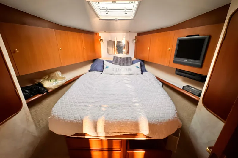 Slide: The Image of Cozy bedroom in 1999 Ocean Yachts 48 Super Sport with wood cabinets and TV. - 13