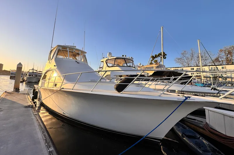 Slide: The Image of 1999 Ocean Yachts 48 Super Sport docked at marina during sunset. - 2