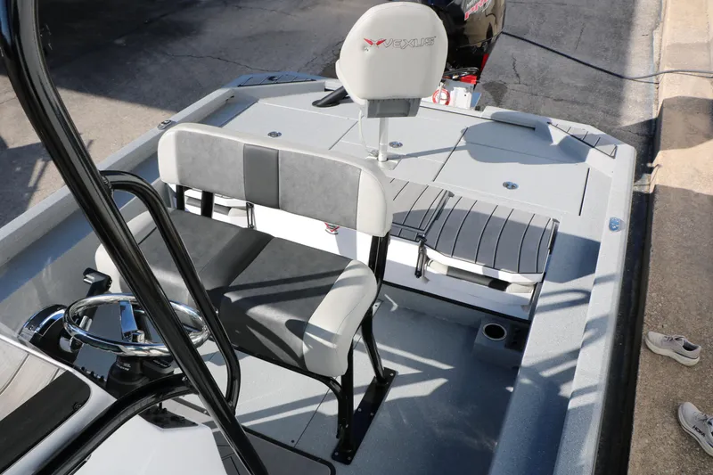 Slide: The Image of 2025 Vexus ACX 2210 boat interior with seating and steering wheel, docked outdoors. - 24