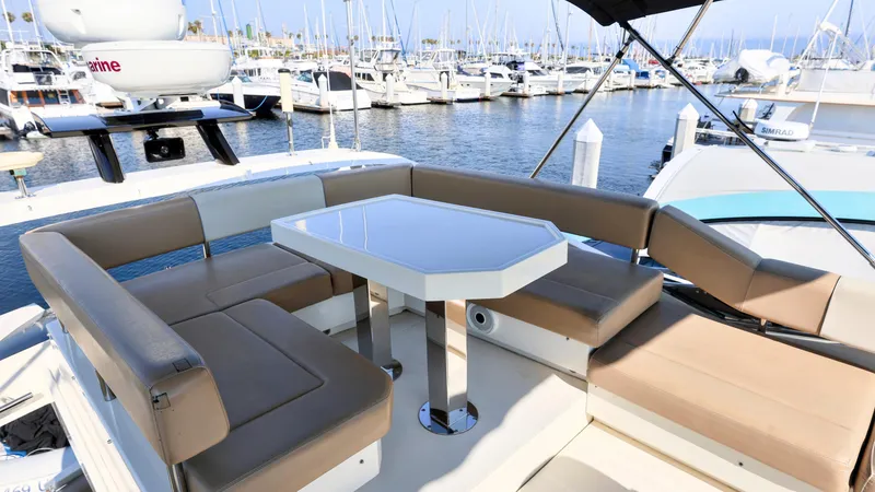 Slide: The Image of 2013 Marquis 500 Sport Bridge yacht with outdoor seating, docked in a marina. - 9