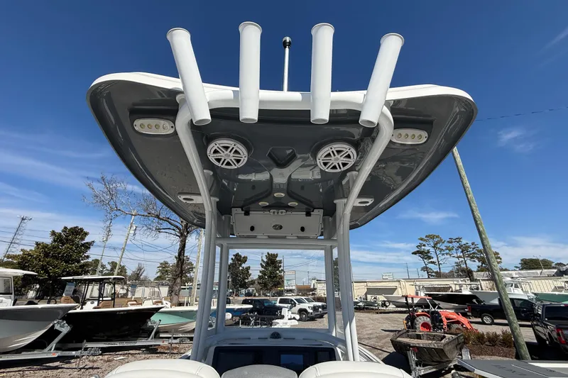 Slide: The Image of 2019 Tidewater 2700 Carolina Bay boat with T-top and rod holders, under clear blue sky. - 19