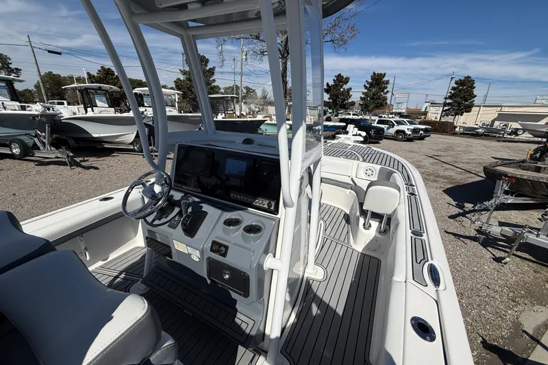 Slide: The Image of 2019 Tidewater 2700 Carolina Bay boat with modern console and seating, parked outdoors. - 26