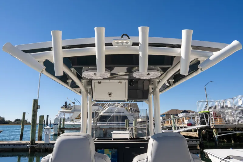 Slide: The Image of 2026 Bay Rider 239 Bay boat with rod holders and seating, docked under clear blue sky. - 10