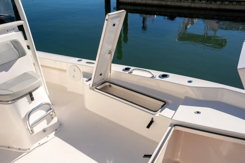 Slide: The Image of 2026 Bay Rider 239 Bay boat interior with open storage compartment by the water. - 27