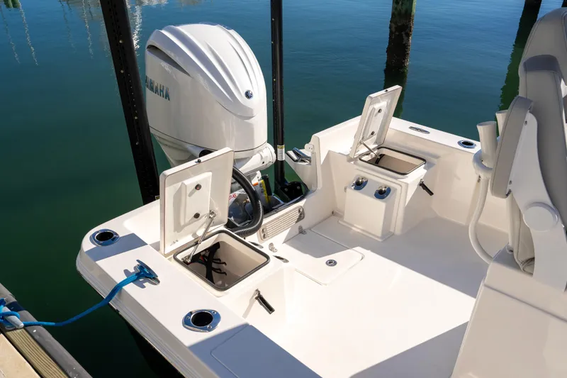 Slide: The Image of 2026 Bay Rider 239 Bay boat with Yamaha engine, docked, featuring open storage compartments. - 30