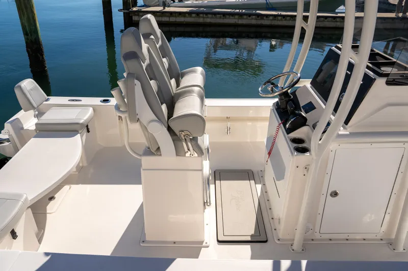 Slide: The Image of 2026 Bay Rider 239 Bay boat interior with helm, seating, and console at marina. - 5