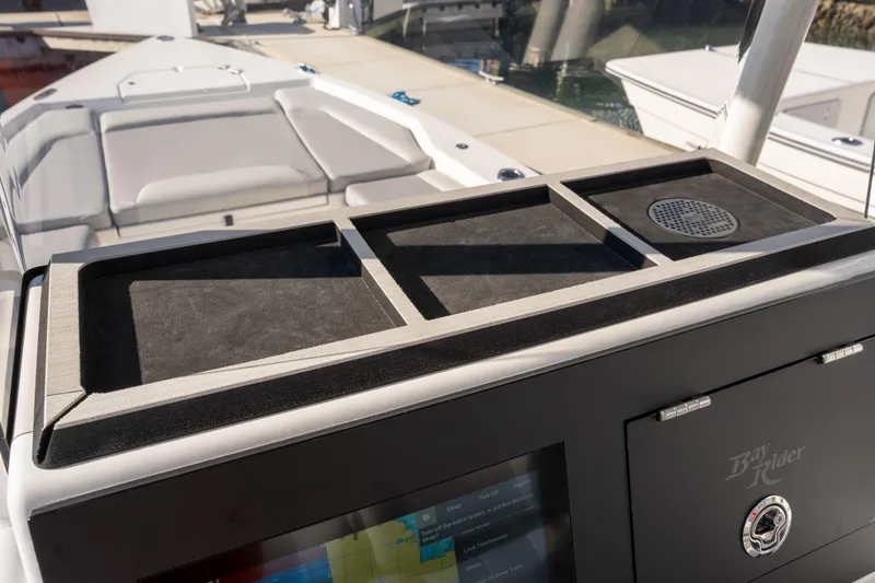 Slide: The Image of 2026 Bay Rider 239 Bay boat console with storage compartments and speaker. - 9