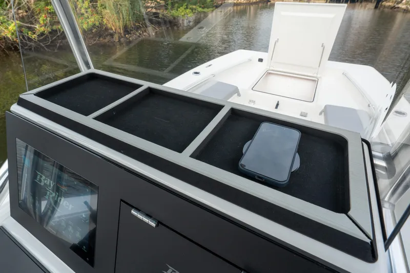 Slide: The Image of 2026 Bay Rider 2260 FS Skiff console with phone holder, docked by water. - 10
