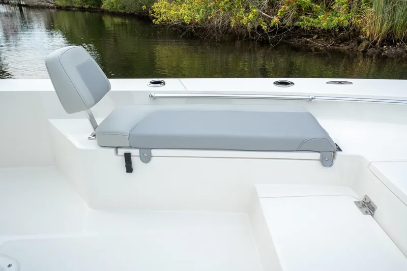 Slide: The Image of Bay Rider 2260 FS Skiff 2026 boat seat with gray cushion, near water and greenery. - 14