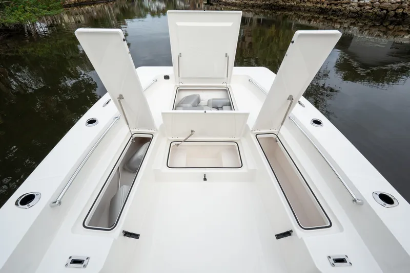 Slide: The Image of 2026 Bay Rider 2260 FS Skiff boat with open storage compartments on calm water. - 19