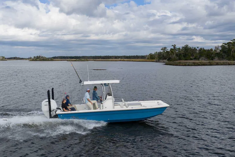 Slide: The Image of 2026 Bay Rider 2260 FS Skiff cruising on a scenic lake under cloudy skies. - 2