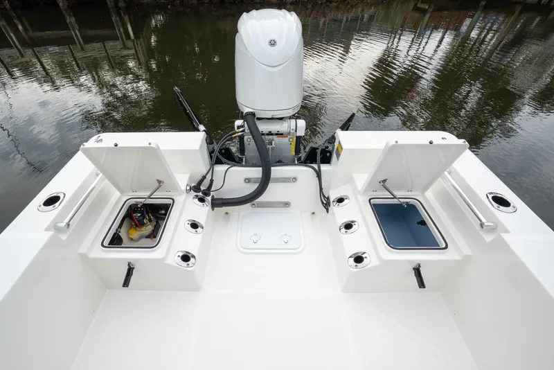Slide: The Image of Bay Rider 2260 FS Skiff 2026 model with open storage compartments and motor, docked by water. - 25