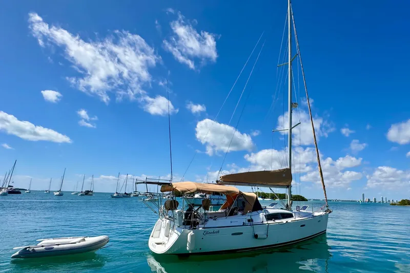 The Image of 2008 Beneteau Oceanis 40 sailboat anchored in a sunny bay with clear skies. - 0