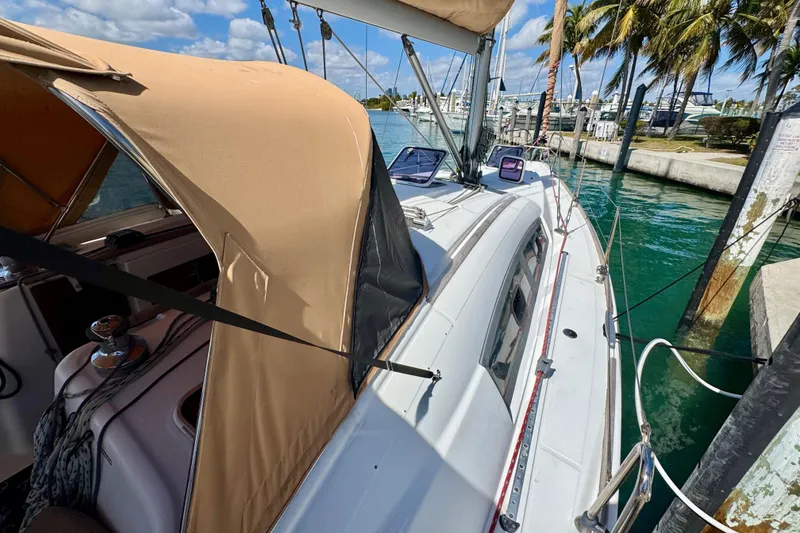Slide: The Image of 2008 Beneteau Oceanis 40 sailboat docked, featuring tan canopy and marina backdrop. - 11