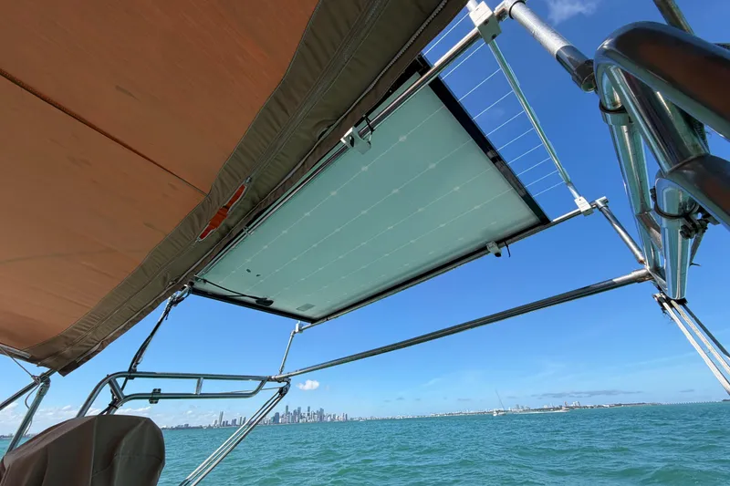 Slide: The Image of Beneteau Oceanis 40 sailboat with solar panel, city skyline in background, clear blue sky. - 55