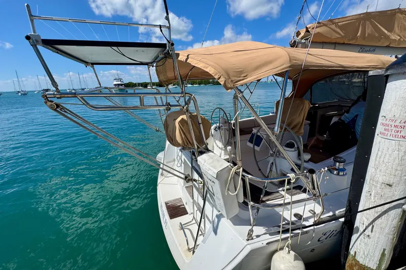 Slide: The Image of Beneteau Oceanis 40 sailboat docked, featuring tan canopy and clear blue water, 2008 model. - 7