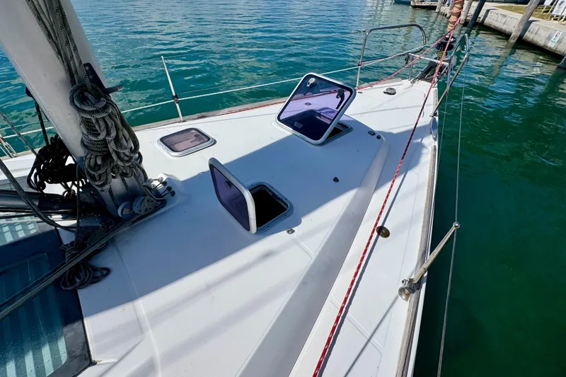 Slide: The Image of 2008 Beneteau Oceanis 40 sailboat deck with open hatches, docked on calm water. - 8