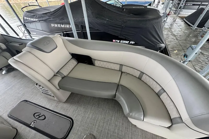 Slide: The Image of Luxurious seating on 2020 Harris Grand Mariner 250 pontoon boat, docked with covered boats nearby. - 12