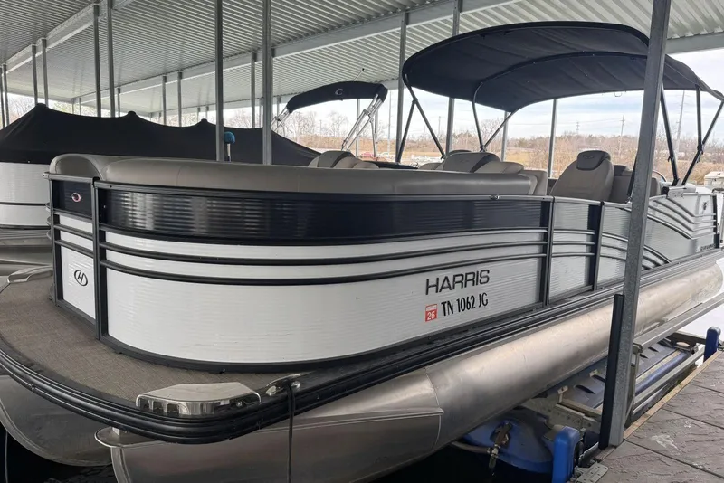 Slide: The Image of 2020 Harris Grand Mariner 250 pontoon boat docked under a covered marina. - 2