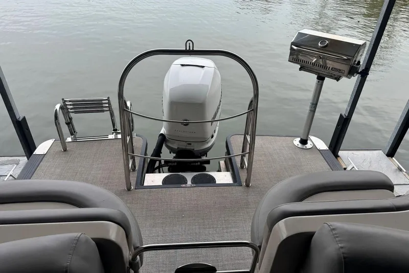 Slide: The Image of 2020 Harris Grand Mariner 250 boat deck with motor and grill by the water. - 25