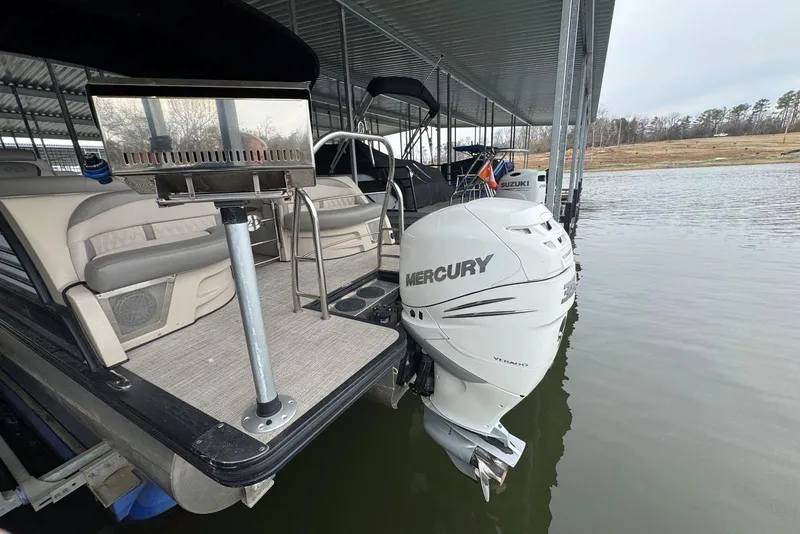 Slide: The Image of 2020 Harris Grand Mariner 250 pontoon boat with Mercury outboard motor docked on a lake. - 4