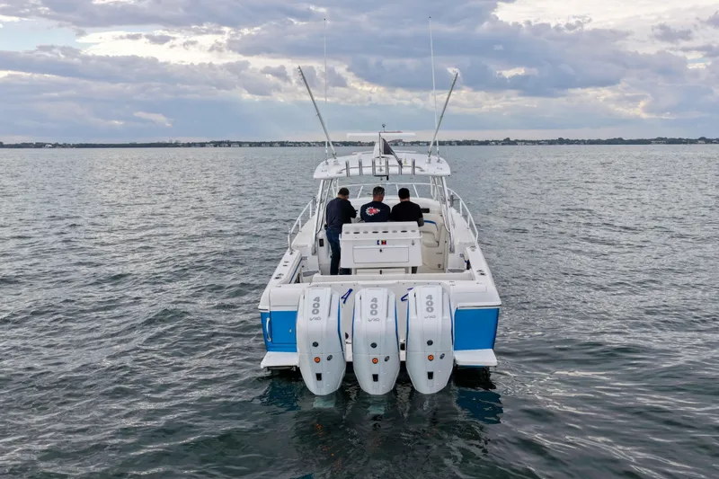 The Image of 2003 Intrepid 377 Walkaround boat with triple engines on open water. - 1