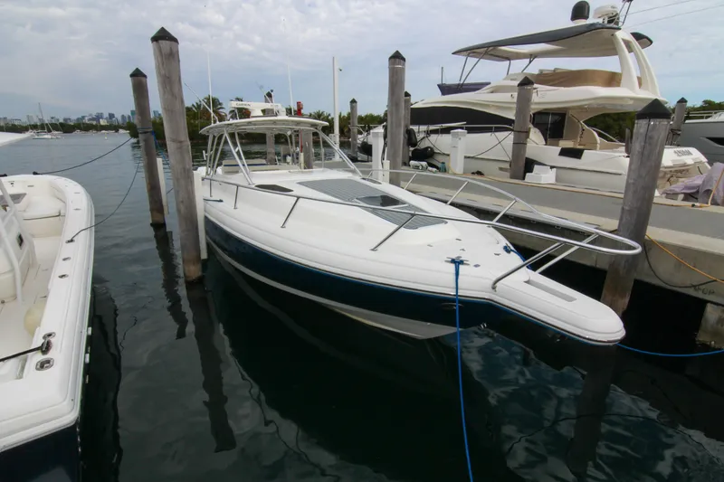 Slide: The Image of 2003 Intrepid 377 Walkaround boat docked at marina, surrounded by other vessels. - 15