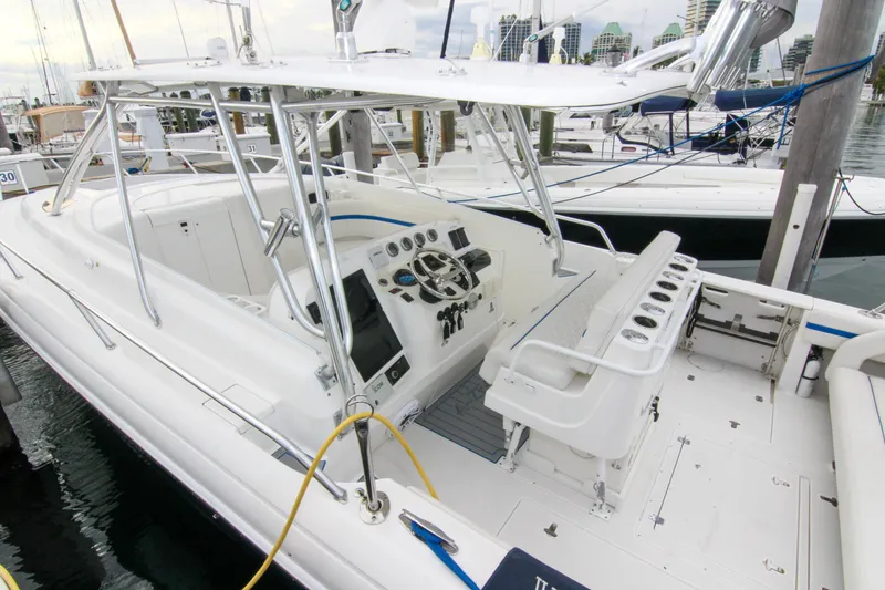 Slide: The Image of 2003 Intrepid 377 Walkaround boat with spacious cockpit and modern controls at a marina. - 18