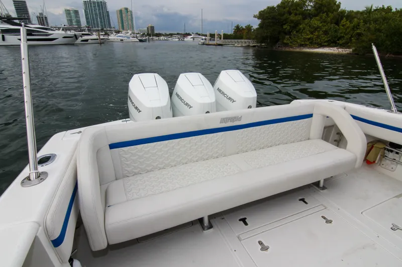 Slide: The Image of 2003 Intrepid 377 Walkaround boat with triple Mercury engines, docked near luxury yachts. - 23