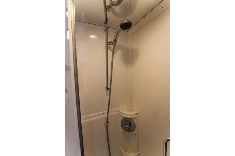 Slide: The Image of Shower area inside a 2003 Intrepid 377 Walkaround boat, featuring a handheld showerhead. - 26