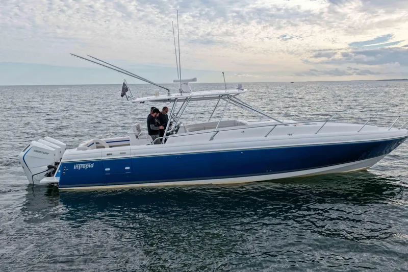 Slide: The Image of 2003 Intrepid 377 Walkaround boat on open water, featuring sleek design and Mercury engines. - 3