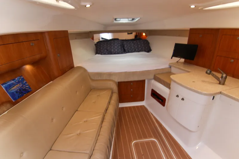 Slide: The Image of 2003 Intrepid 377 Walkaround cabin with bed, sofa, and kitchenette. - 31