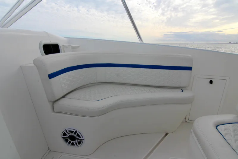 Slide: The Image of 2003 Intrepid 377 Walkaround boat interior seating with blue accents and ocean view. - 34