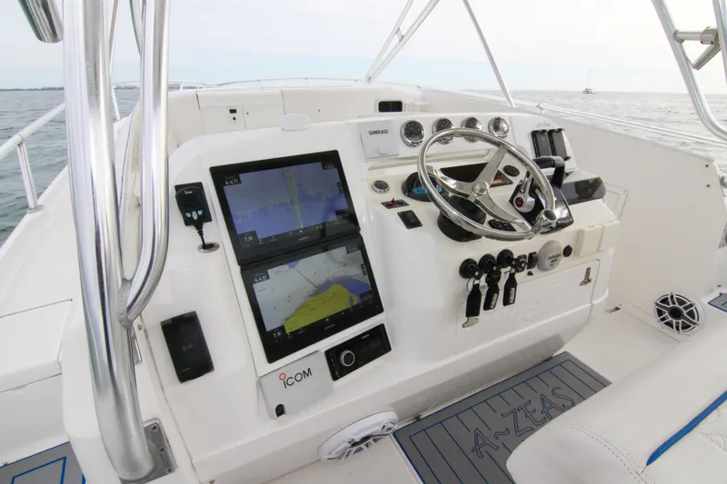 Slide: The Image of 2003 Intrepid 377 Walkaround boat helm with navigation screens and steering wheel. - 35