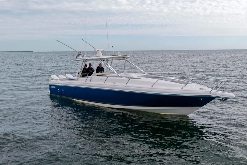 Slide: The Image of 2003 Intrepid 377 Walkaround boat on open water, featuring sleek design and blue hull. - 4