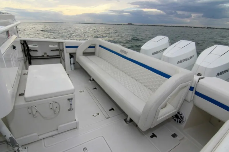 Slide: The Image of 2003 Intrepid 377 Walkaround boat interior with seating and Mercury engines on open water. - 43