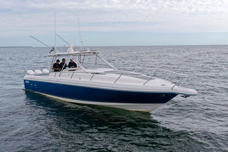 Slide: The Image of 2003 Intrepid 377 Walkaround boat on open water, featuring sleek design and blue hull. - 5