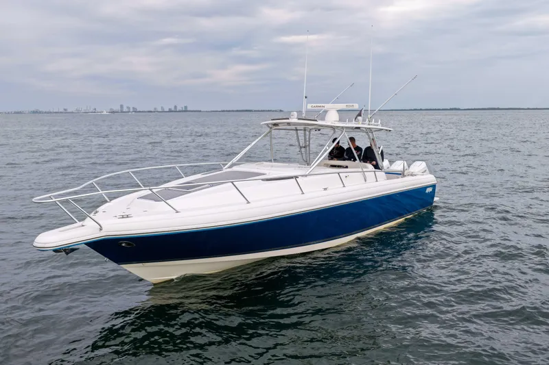 Slide: The Image of 2003 Intrepid 377 Walkaround boat on open water, featuring a sleek blue and white design. - 7
